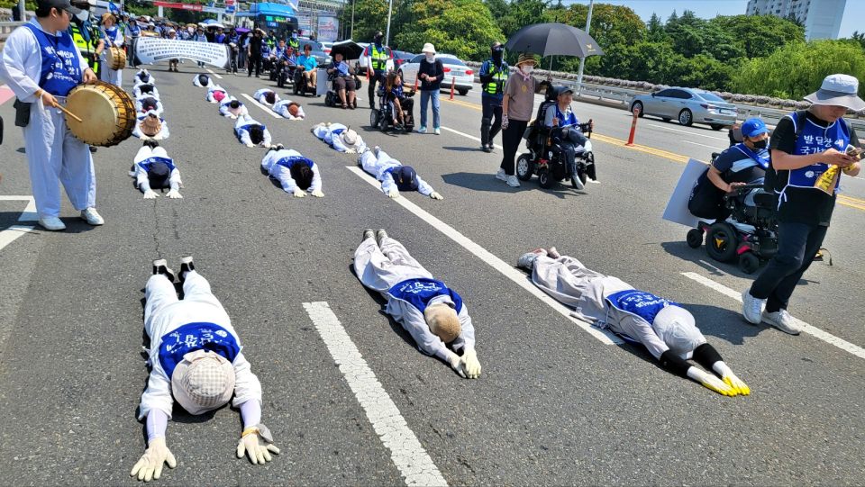 "발달장애인 가정의 죽음은 사회적 참사...더 이상 비극 막아댤라"...장애인 자녀를 가진 부모들이 대구시청 산격청사 앞 도청교 콘크리트 도로 위에서 오체투지를 하고 있다.(2024.6.11) / 사진.평화뉴스 김영화 기자 