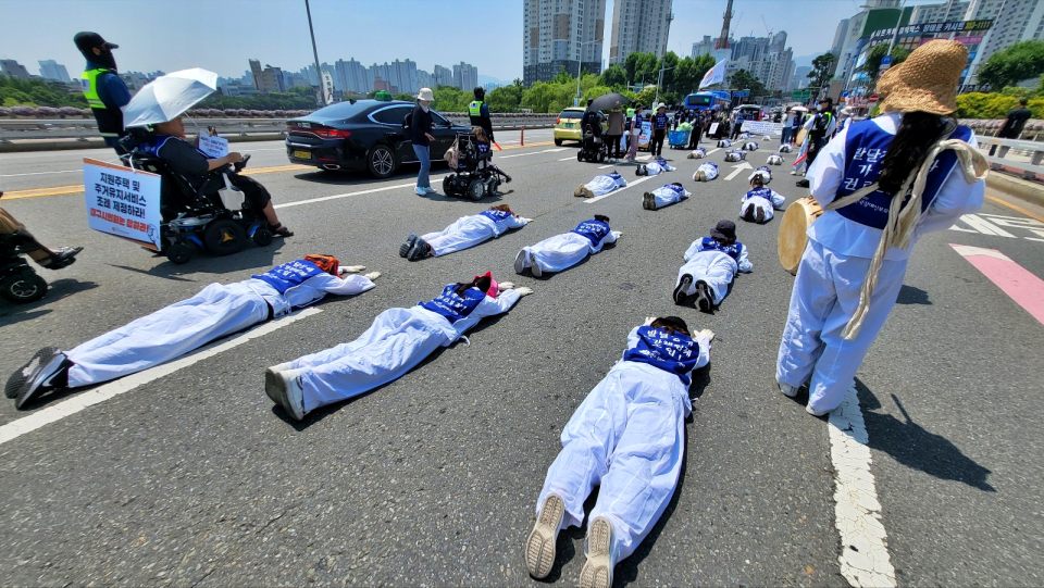 낮 기온 34도 대구의 폭염 속에서 땅바닥에 누워 오체투지를 하며 발달장애인 가정 지원 체계 구축을 촉구하는 장애인 자녀를 가진 부모들(2024.6.11) / 사진.평화뉴스 김영화 기자