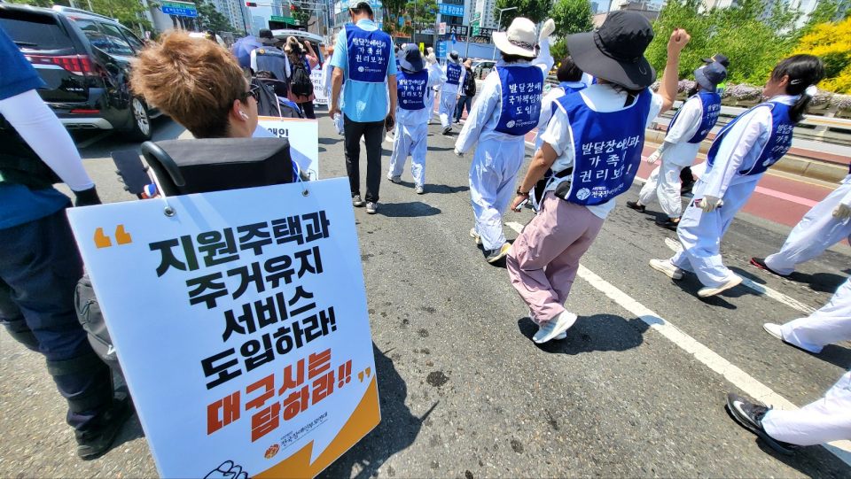 "발달장애인 지원주택과 주거유지 서비스 도입하라" 대구 북구 침산동 도청교를 행진하는 장애인부모단체 회원들(2024.6.11) / 사진.평화뉴스 김영화 기자
