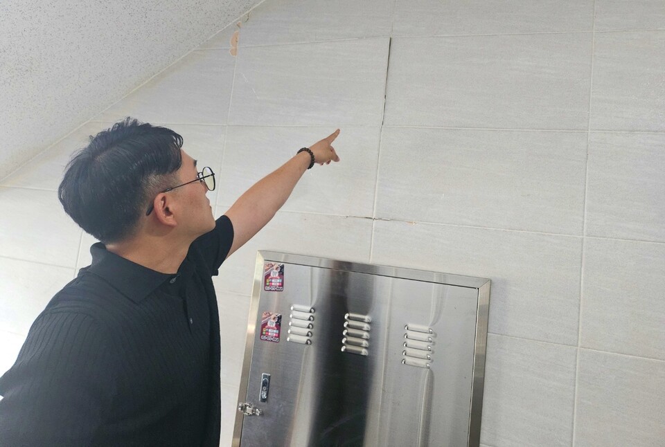 최성준 공동위원장이 건물 벽면의 파손된 부분을 가리키고 있다.(2024.6.14) / 사진.평화뉴스 정준민 기자