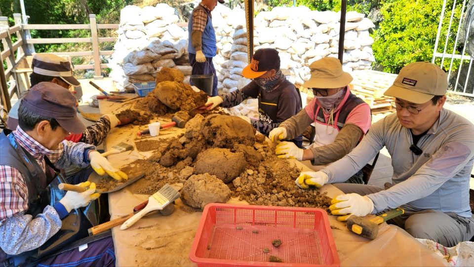 포대자루를 하나씩 풀어 작업대에 올려놓고 고무망치와 솔로 조심스럽게 뼈를 찾는 작업을 하고 있다.(2024.6.18) / 사진.평화뉴스 김영화 기자