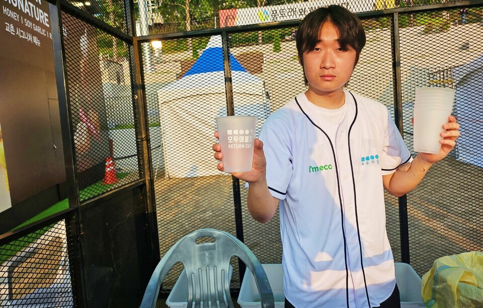 다회용기 수거 부스 직원이 다회용 컵을 들고 있는 모습(2024.7.3) / 사진.평화뉴스 정준민 기자