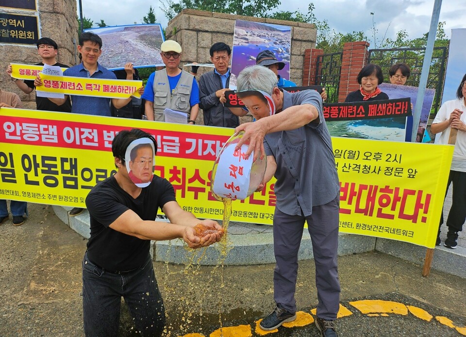 권기창 안동시장이 중금속에 오염된 안동댐 물을 홍준표 대구시장에게 붓는 퍼포먼스를 진행하고 있다.(2024.7.15) / 사진.평화뉴스 정준민 기자