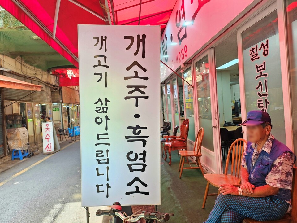 칠성개시장 한 보신탕집에서 한 시민이 식사를 하고 나온 뒤 앉아 있다.(2024.7.25) / 사진.평화뉴스 정준민 기자