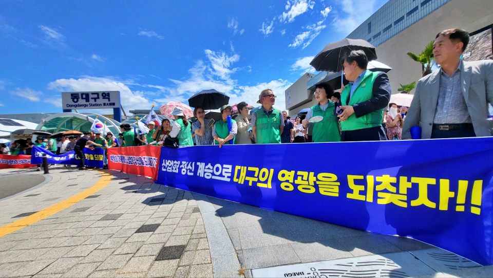새마을회 회원들이 '박정희 광장' 표지판 제막식 현장에서 "산업화 정신 계승으로 대구의 영광을 되찾자"고 적힌 현수막을 들고 있다.(2024.8.14) / 사진.평화뉴스 김영화 기자