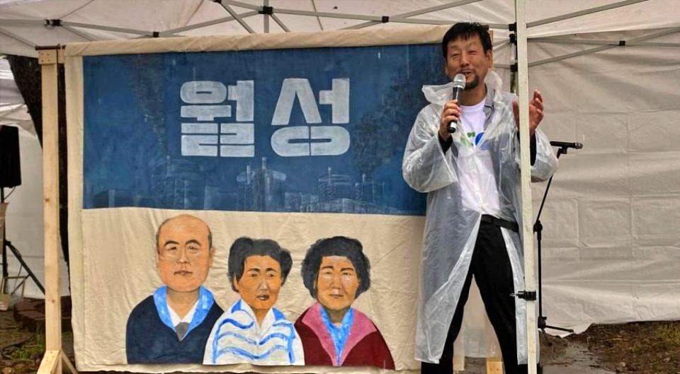 '월성'이라고 적힌 그림 아래 원전 인근 마을 주민들의 얼굴이 담겼다. 10년 대회에 참여한 시민이 발언을 하고 있다.(2024.9.21) / 사진.월성원전이주대책위10년추진위 