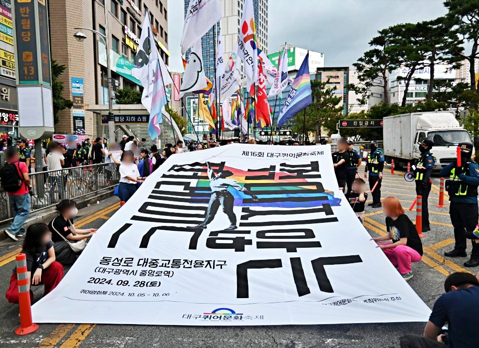 제16회 대구퀴어문화축제 '꺾이지 않는 퍼레이드' 현수막을 펼치고 반월당 네거리 달구벌대로에서 행진하는 성소수자들(2024.9.28) / 사진.평화뉴스 정준민 기자