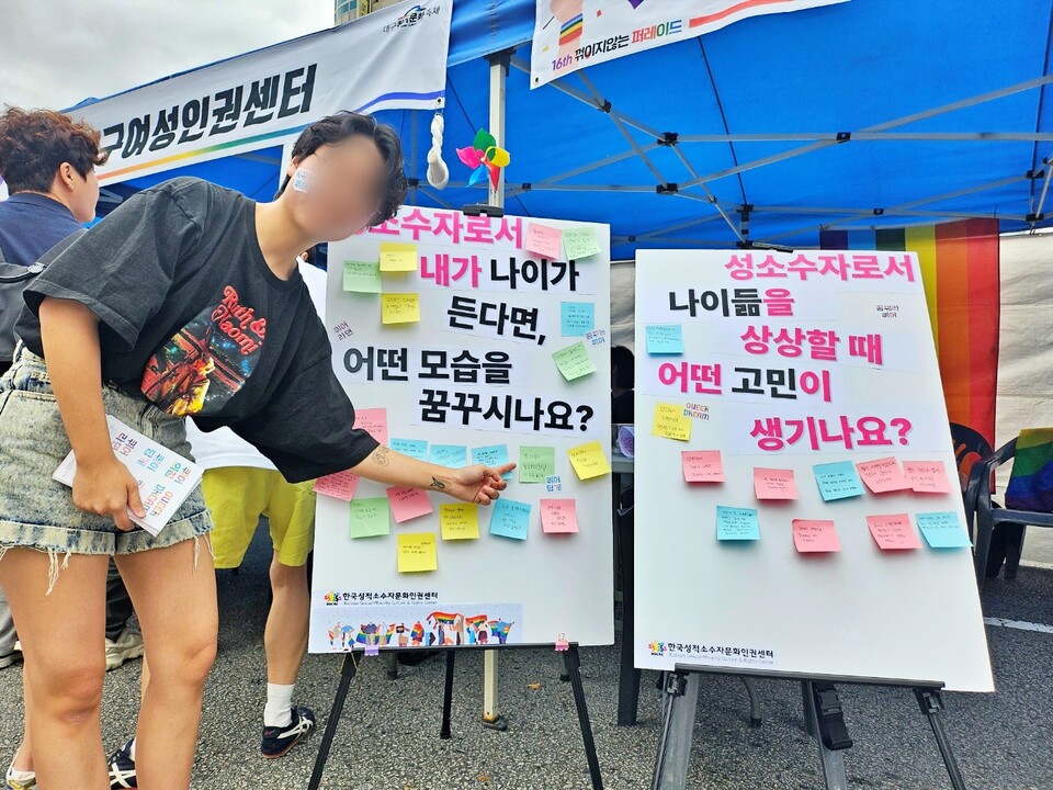 "성소수자로서 내가 나이가 든다면 어떤 삶을 원하나요"라고 적힌 설문에서 한국성소수자문화인권센터 활동가가 답변을 적은 메모지를 가리키고 있다.