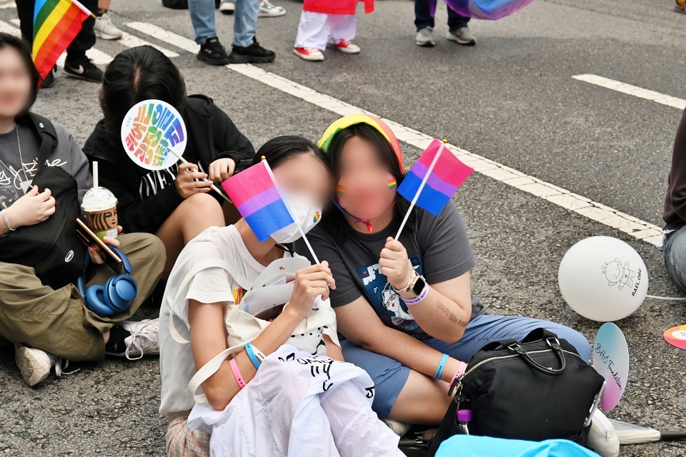 제16회 대구퀴어문화축제에 참가한 시민들이 볼과 마스크에 무지개 색 하트를 붙이고 깃발을 흔들고 있다.(2024.9.28) / 사진.평화뉴스 정준민 기자