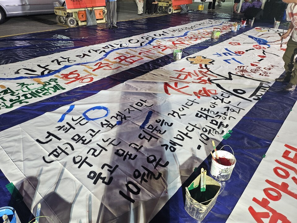 "너희는 파묻고 싶겠지만 우리는 묻고, 묻고, 되물을 것이다"...시민들이 10월항쟁의 의미를 10m 길이의 긴 종이에 적었다.(2024.9.30) / 사진.평화뉴스 정준민 기자