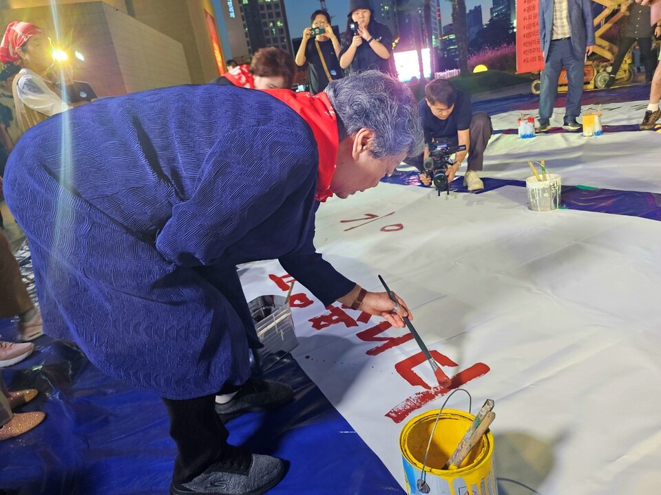 채영희 10월항쟁유족회 이사장이 전야제에 참석한 예술가들과 시민들을 향해 "고맙습니다"라고 종이에 적고 있다.(2024.9.30) / 사진.평화뉴스 정준민 기자