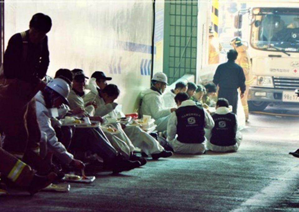 대구 서문시장 4지구 화재현장에서 소방관들이 방재복을 입고 방화 작업을 하다 바닥에 앉아 컵라면 등을 먹으며 식사를 하고 있다.(2016.12.23) / 사진.평화뉴스   