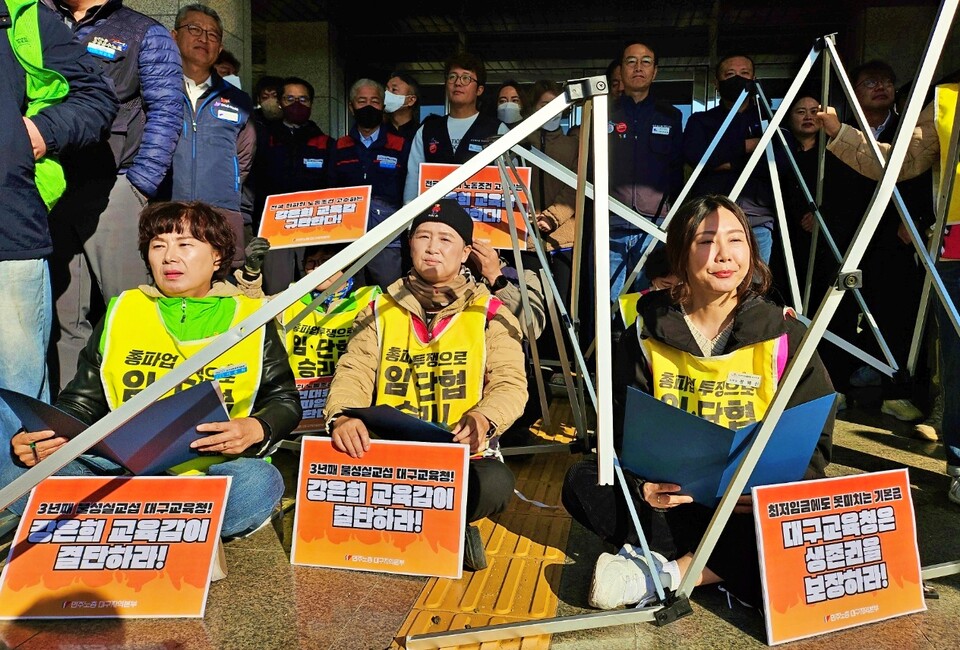 (왼쪽부터) 서춘화 전국교육공무직본부 대구지부장, 정경희 전국학교비정규직노조 대구지부장, 정혜진 전국여성노조 대구지부장이 부서진 천막 안에 앉아 농성 중이다.(2024.11.20.대구교육청 앞) / 사진.평화뉴스 정준민 기자