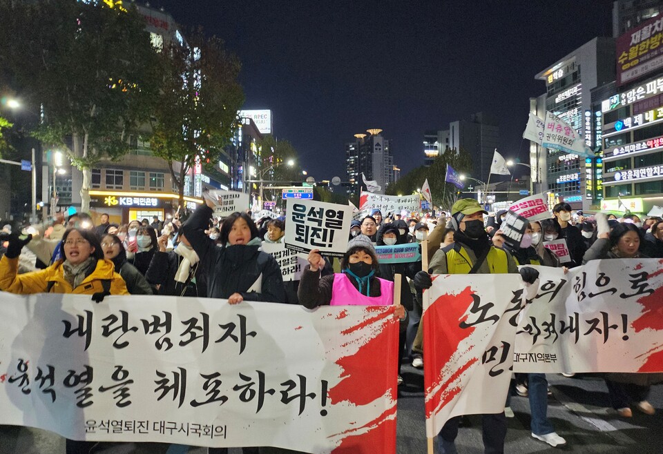 "내란범죄자 윤석열을 체포하라"...시민들이 현수막을 앞세워 행진을 펼치고 있다.(2024.12.7) / 사진.평화뉴스 정준민 기자