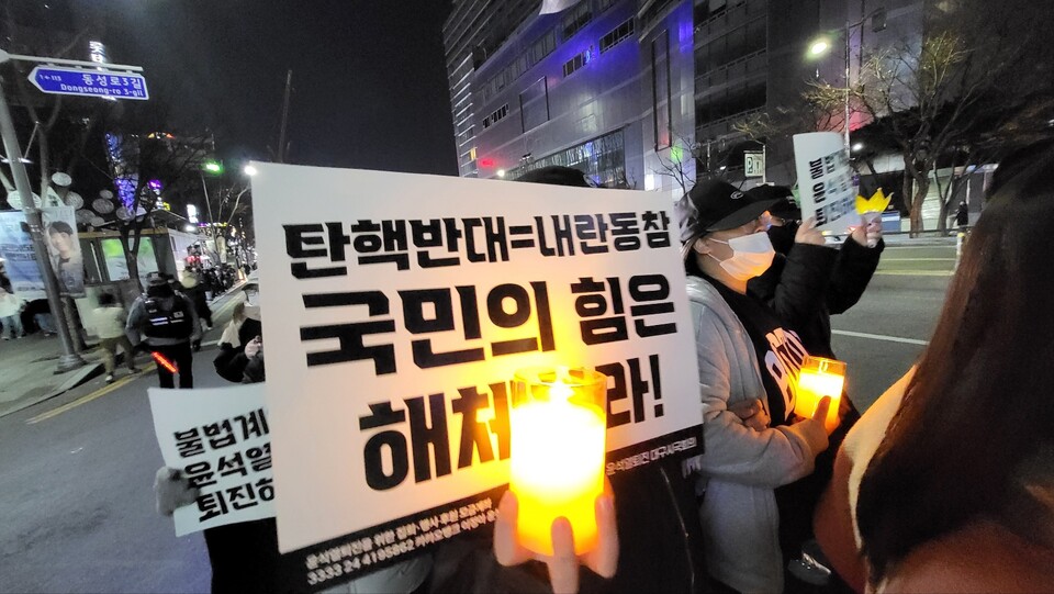 "탄핵 반대는 내란 동참, 국민의힘 해체하라" 20대 청년이 촛불과 함께 피켓을 들고 2.28공원 앞 대로를 행진하고 있다.(2024.12.7) / 사진. 평화뉴스 김영화 기자