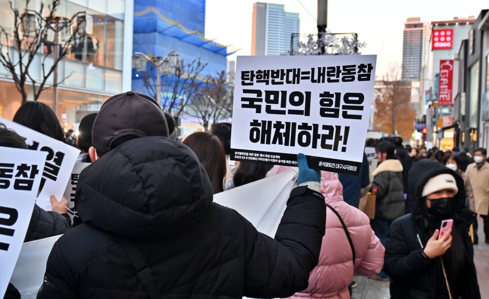 "탄핵반대는 내란동참, 국민의힘은 해체하라" 동성로 시위에서 피켓을 들고 있다.
