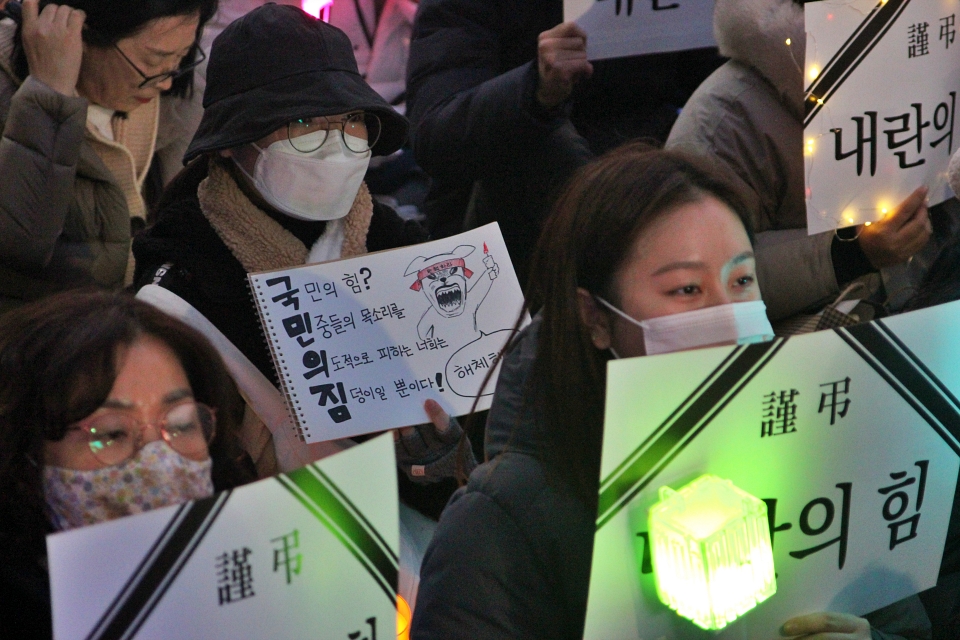 "국민의힘? 민중들의 목소리를 의도적으로 피하는 너희는 짐덩이일 뿐이다"라고 적힌 피켓을 들고 있는 모습(2024.12.11) / 사진.평화뉴스 정준민 기자