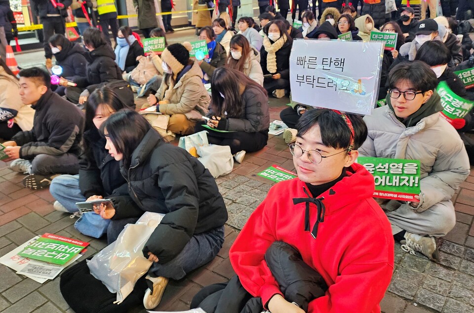 "빠른 탄핵 부탁드려요" 라고 적힌 피켓을 머리띠에 부착해 쓰고 있다.(2024.12.13) / 사진.평화뉴스 정준민 기자