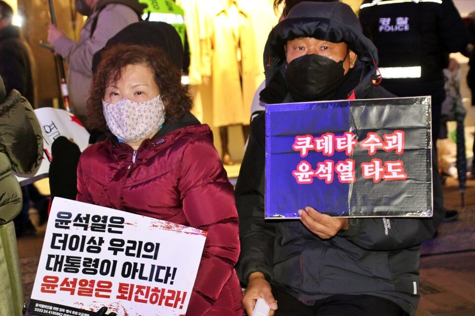 "쿠데타 수괴, 윤석열 타도...윤석열 더 이상 우리의 대통령이 아니다" 피켓을 든 촛불 든 시민들(2024.12.13) / 사진.평화뉴스 김영화 기자