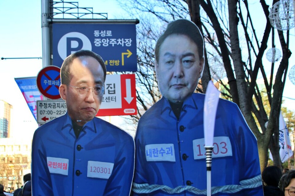 대구 시국대회에서 한 시민이 추경호(대구 달성군) 전 국민의힘 원내대표와 윤석열 대통령이 수의를 입고 체포된 모습의 전신 피켓을 들고 있다.(2024.12.14) / 사진.평화뉴스 김영화 기자