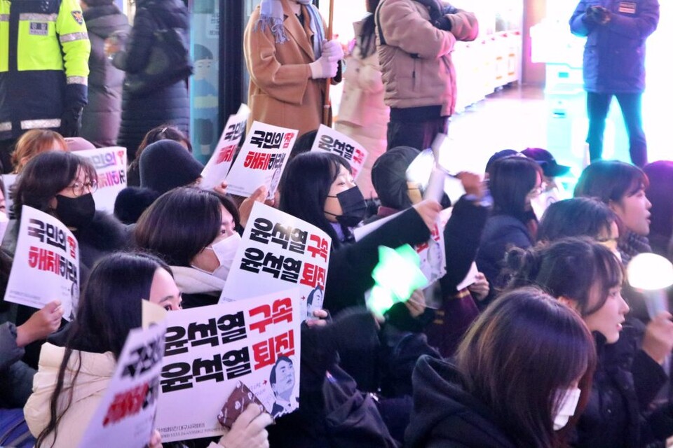 2030 젊은 여성들이 대구 동성로에서 열린 제5차 윤석열 퇴진 탄핵집회에서 "윤석열 구속, 윤석열 퇴진" 피켓을 들고 응원봉을 흔들고 있다.(2024.12.9) / 사진.평화뉴스 김영화 기자