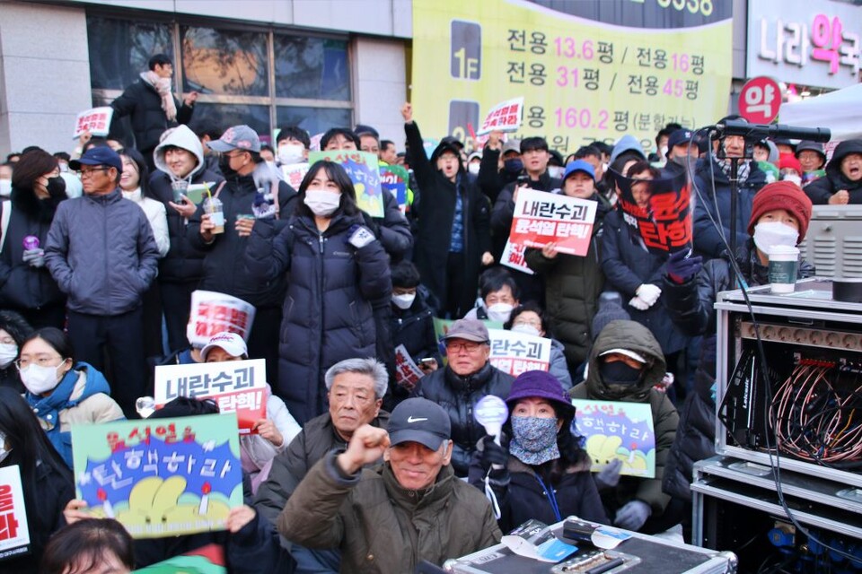 대구 탄핵집회가 열린 국채보상로 중앙 무대 앞 자리가 아닌 옆 인도에 앉은 40~60대 중·장년층의 모습(2024.12.14) / 사진.평화뉴스 김영화 기자 