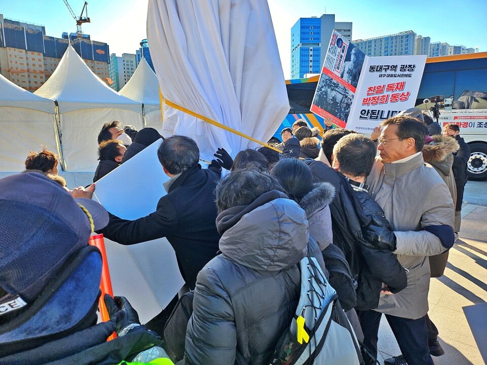시민단체 인사들이 박정희 동상을 덮은 천을 벗기려 하고 있다.(2024.12.22) / 사진.평화뉴스 정준민 기자
