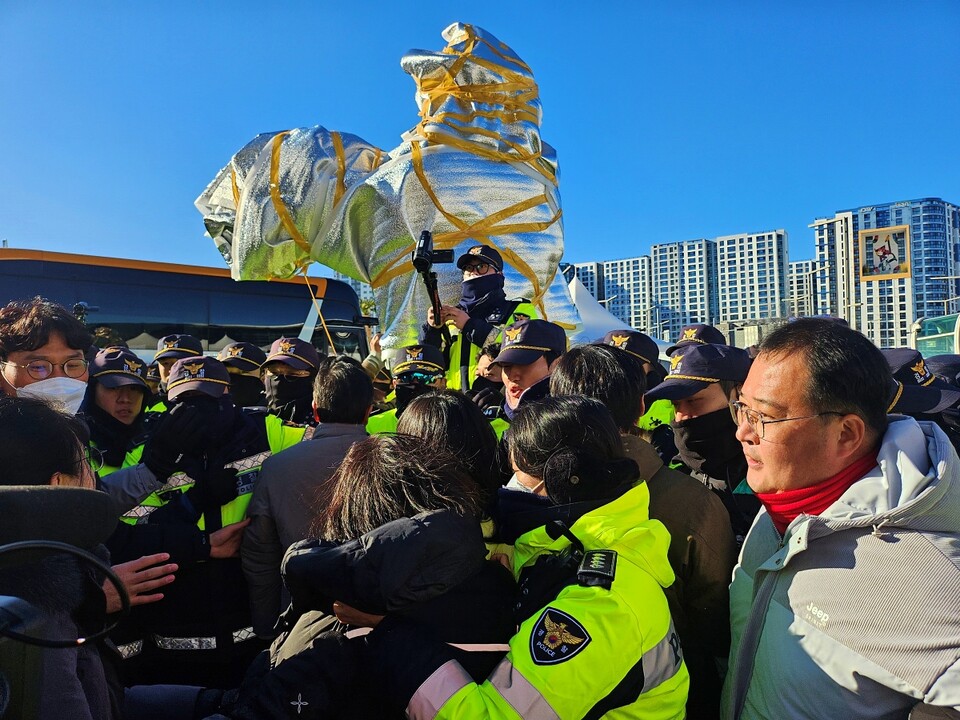 박정희 동상을 덮은 천을 벗겼으나 단열재에 동상이 싸여 있고, 시민단체 인사들과 경찰이 충돌하는 모습(2024.12.22) / 사진.평화뉴스 정준민 기자