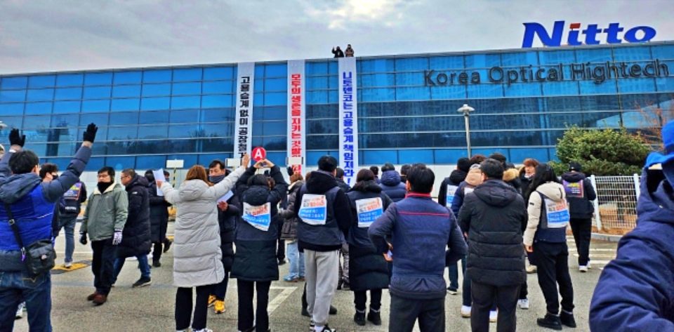 폐업한 경북 구미 한국옵티칼하이테크 공장 옥상에서 고공농성 중인 두 여성 해고자들을 향해 조합원들이 손을 흔들고 있다.(2024.1.9) / 사진.평화뉴스 정준민 기자