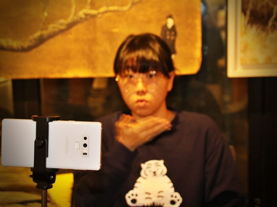 0+0 유튜브 채널 운영자인 제희정씨가 삼각대에 휴대폰을 올려놓고 수어를 하며 영상을 촬영 중이다.(2025.1.2) / 사진.평화뉴스 김영화 기자 