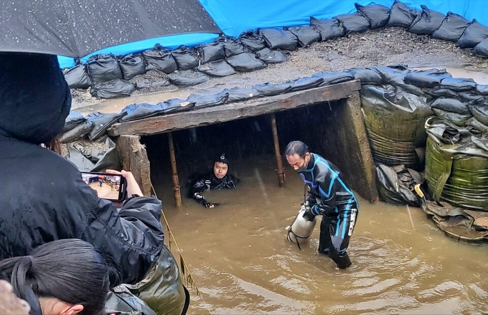 갱도의 입구에서 105분간의 수중 유해발굴 작업을 마치고 물 밖으로 나오는 잠수부 이사지 요시타카씨의 모습(2025.2.1) / 사진.평화뉴스 김영화 기자