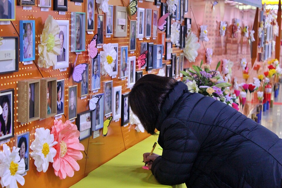 한 시민이 추모의 벽에 희생자들을 향한 추모 메시지를 적고 있다.(2025.2.12) / 사진.평화뉴스 정준민 기자