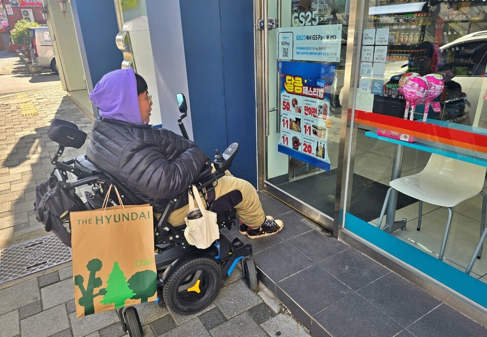 휠체어를 탄 한 장애인이 대구 중구의 한 편의점에서 계단에 막혀 들어가지 못하는 모습(2025.2.17) / 사진 제공.대구장애인차별철폐연대 