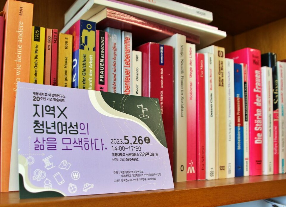 '지역 X 청년여성의 삶을 모색하다'를 주제로 열린 계명대 여성학연구소 20주년 기념 학술대회의 초청장이 안 교수 연구실 책장에 놓였다.(2025.2.26) / 사진.평화뉴스 김영화 기자