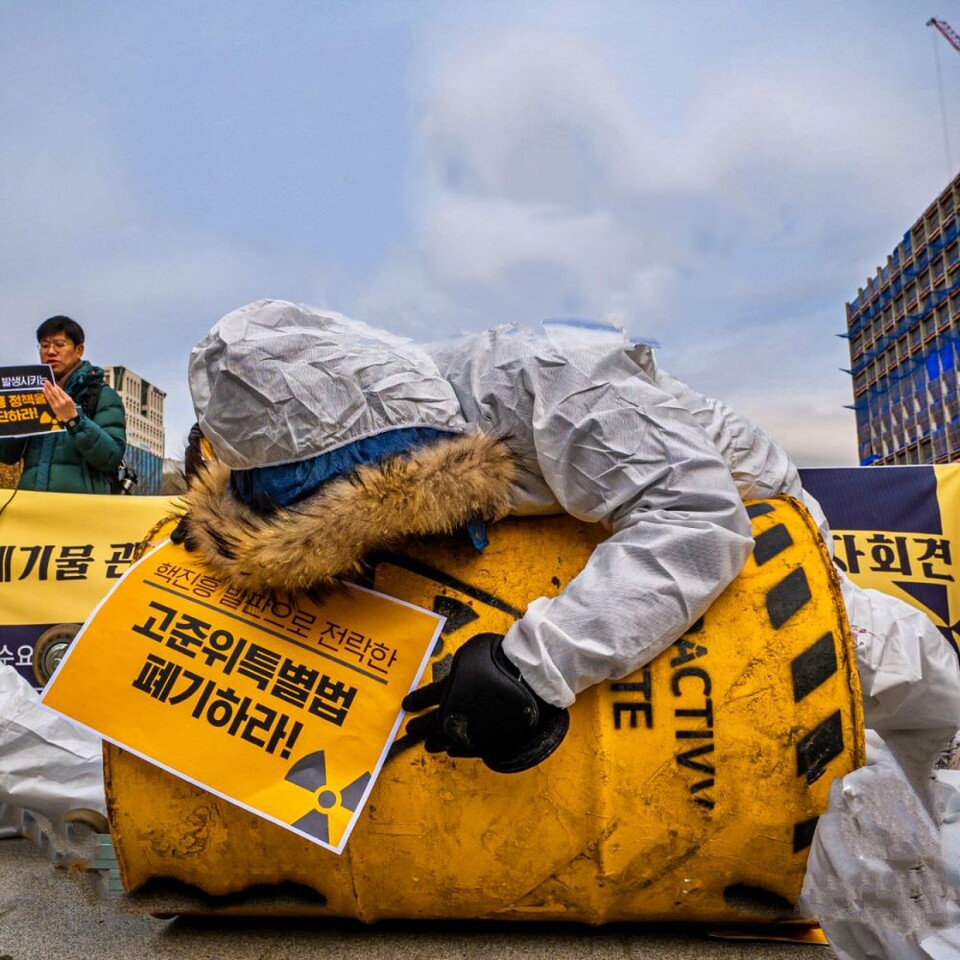 "고준위특별법 폐기하라" 환경운동가가 핵폐기물을 끌어안는 퍼포먼스를 벌이고 있다. / 사진.환경운동연합