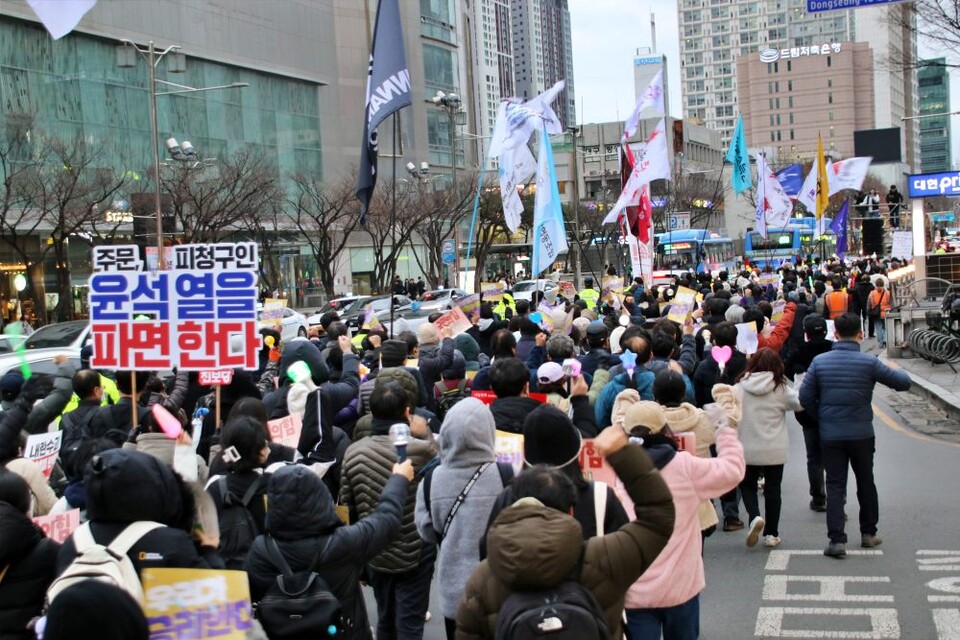 "주문, 피청구인 윤석열을 파면한다" 한 시민이 피켓을 들고 국채보상로 도로 위에서 행진하고 있다.(2025