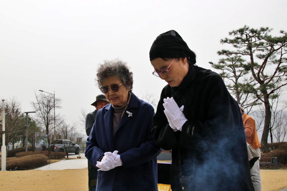 인혁당 재건위 조작사건의 희생자인 사형수 김용원씨의 부인 류승옥씨와 이수병씨의 부인 이정숙씨가 인혁당 50주기를 맞아 묘역에서 기도를 하고 있다.(2025.3.25) / 사진.평화뉴스 김영화 기자