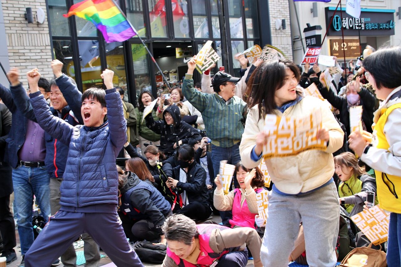 동성로 광장에 모인 시민들은 윤석열 대통령 파면 선고 소식이 나오자 자리에서 일어나 주먹을 쥐고 기뻐했다.(2025.4.4) / 사진.평화뉴스 김영화 기자 