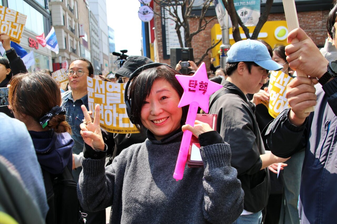 '탄핵'이 적힌 응원봉을 든 시민은 파면 직후 분홍색 응원봉을 흔들며 자리에서 방방 뛰었다.(2025.4.4) / 사진.평화뉴스 김영화 기자