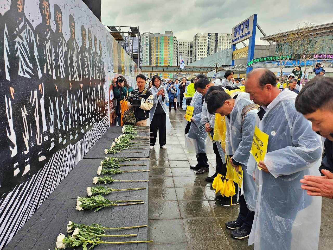 대구 시민들이 인혁당 희생자들을 그린 그림 앞에 헌화하고 묵념하고 있다.(2025.4.5) / 사진.평화뉴스 정준민 기자