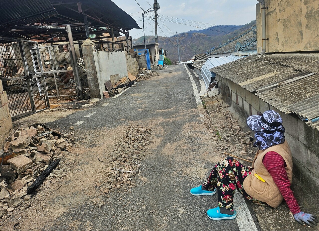 이재민이 된 김모(85) 할머니가 길가에 앉아 전소된 집을 바라보고 있다.(2025.4.18) / 사진.평화뉴스 정준민 기자