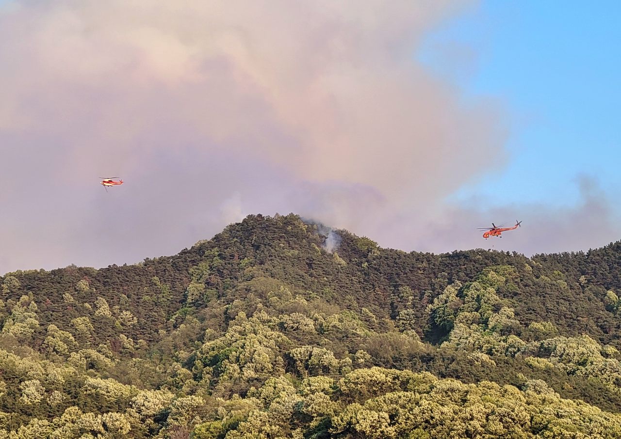 헬기가 함지산 인근 화재 현장에 물을 뿌리며 진화 중이다.(2025.4.28) / 사진.독자 신동우 제공