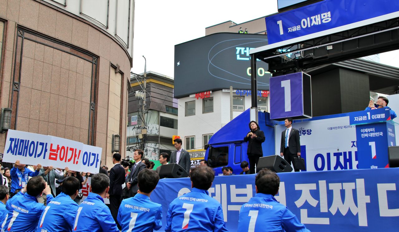 "재매이가 남이가" 피켓을 든 지지자들. 민주당 상직색인 파란색에 붉은색 표시가 있는 점퍼를 입은 선대위원들(2025.5.13) / 사진.평화뉴스 김영화 기자 