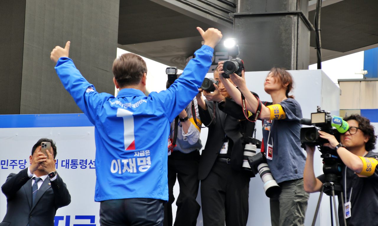 자신의 '기호 1번'을 뜻하는 엄지 척을 하며  대형 유세차량 위에서 지지자들과 기념촬영을 하는 이 후보(2025.5.13) / 사진.평화뉴스 김영화 기자