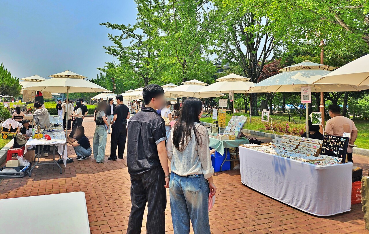 계명대학교 성서캠퍼스에 설치된 플리마켓을 학생들이 구경하는 모습(2025.5.28) / 사진.평화뉴스 정준민 기자