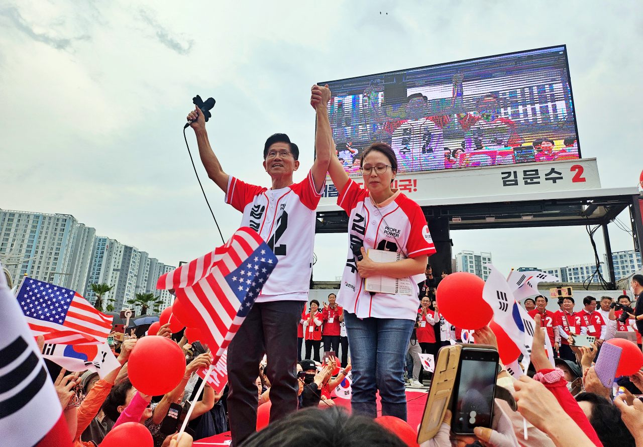 딸 김동주씨의 팔을 들어 보이며 지지자들에게 한 표를 호소하는 김문수 후보. 지지자들은 태극기와 성조기를 흔들며 그의 이름을 연호했다.(2025.6.2) / 사진.평화뉴스 정준민 기자  