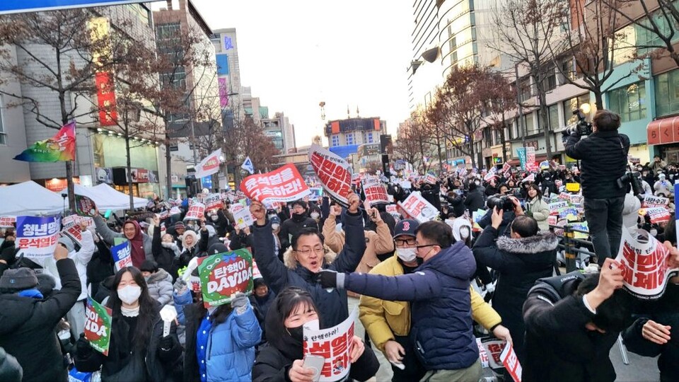 윤석열 대통령 탄핵소추안이 국회를 통과하자 국채보상로에서 함께 중계를 지켜보던 시민들이 자리에서 일어나 기뻐하고 있다.(2024.12.14) / 사진. 평화뉴스 김영화 기자