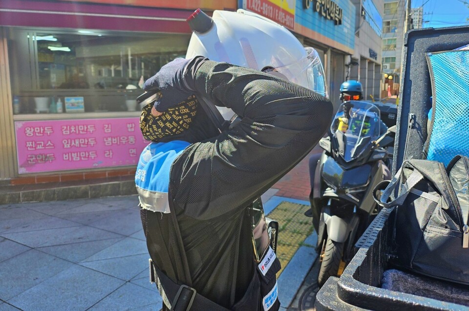 한 배달노동자가 목에 얼음주머니를 대며 더위를 식히고 있다.(2024.8.14) / 사진.평화뉴스 정준민 기자