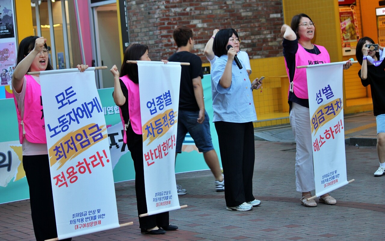 "모든 노동자에게 최저임금 적용", "업종별 차등적용 반대", "성별임금격차 해소" 족자를 펼치며 구호를 외치고 있다.(2025.6.23) / 사진.평화뉴스 정준민 기자