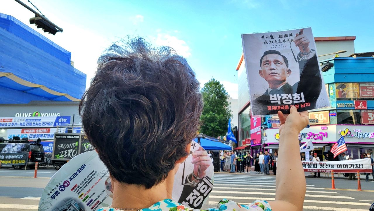 "박정희 대통령 정신 이어가자"...대구 중구 동성로 횡단보도 앞에서 보수단체 회원들이 '박정희 기념사업'을 옹호하는 집회를 열었다. 한 회원이 박정희 전 대통령 사진을 틀고 그의 이름을 연호하고 있다.(2024. 